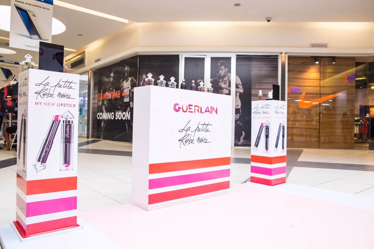 Guerlain La Petite Robe Noire 'My New Lipstick' floor plinths in a shopping mall, printed in pink and magenta
