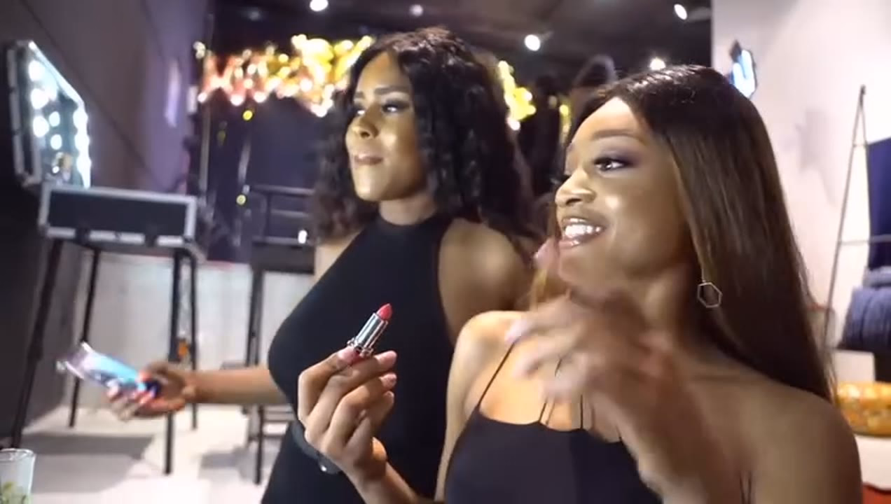 A Guerlain lipstick counter at a beauty event, with a visitor being served