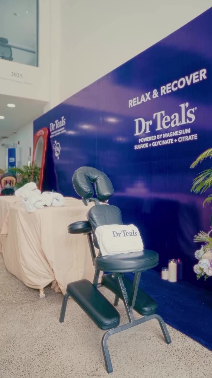 A black pedicure chair with a Dr Teal's towel, against the RELAX & RECOVER backdrop